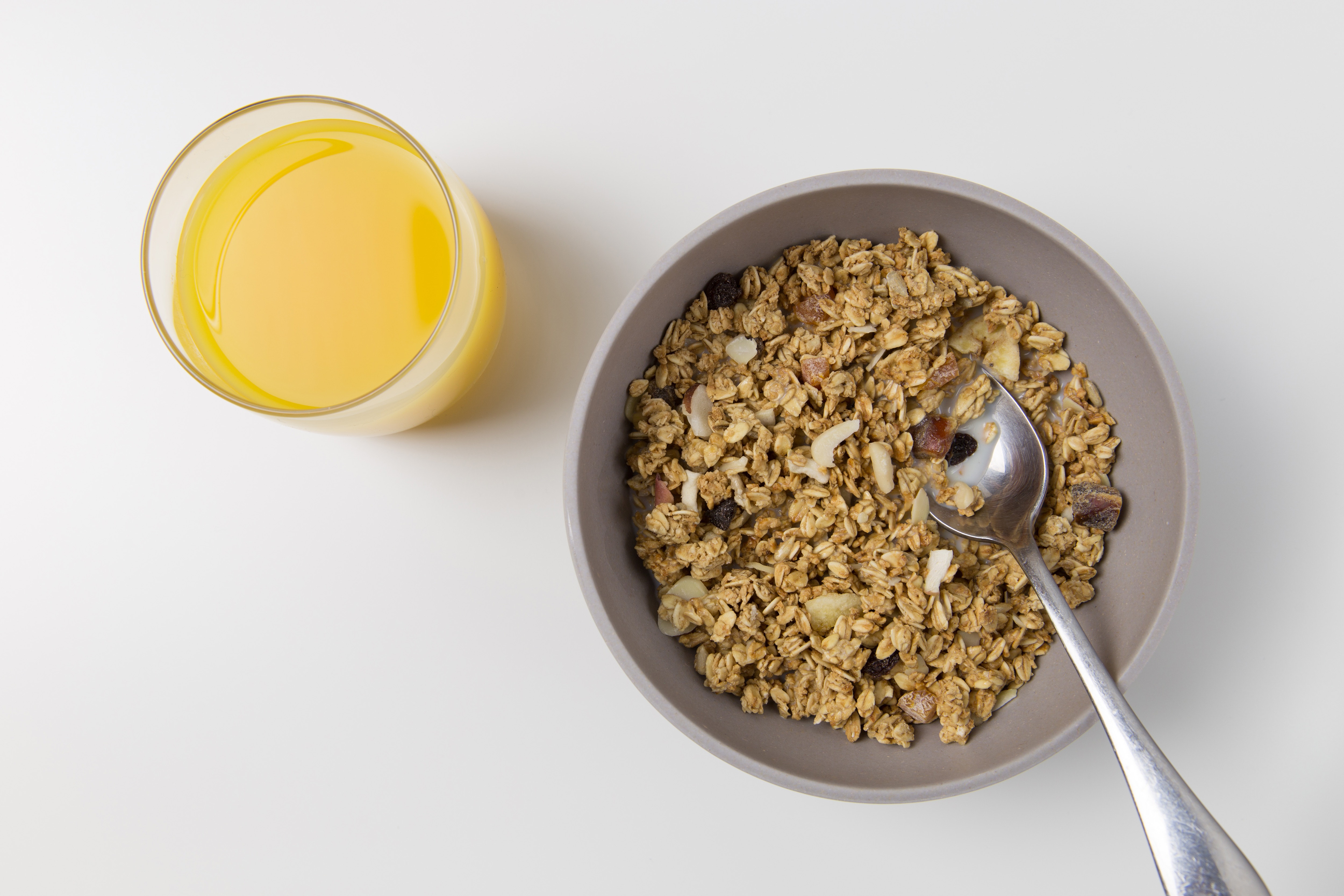 bowl of granola and a glass of orange juice
